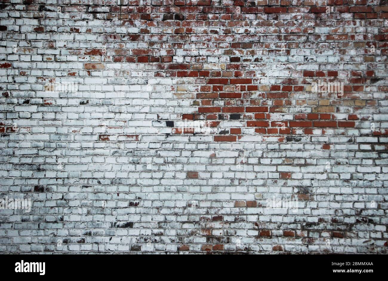 Old weathered vintage brick wall partialy painted white Stock Photo