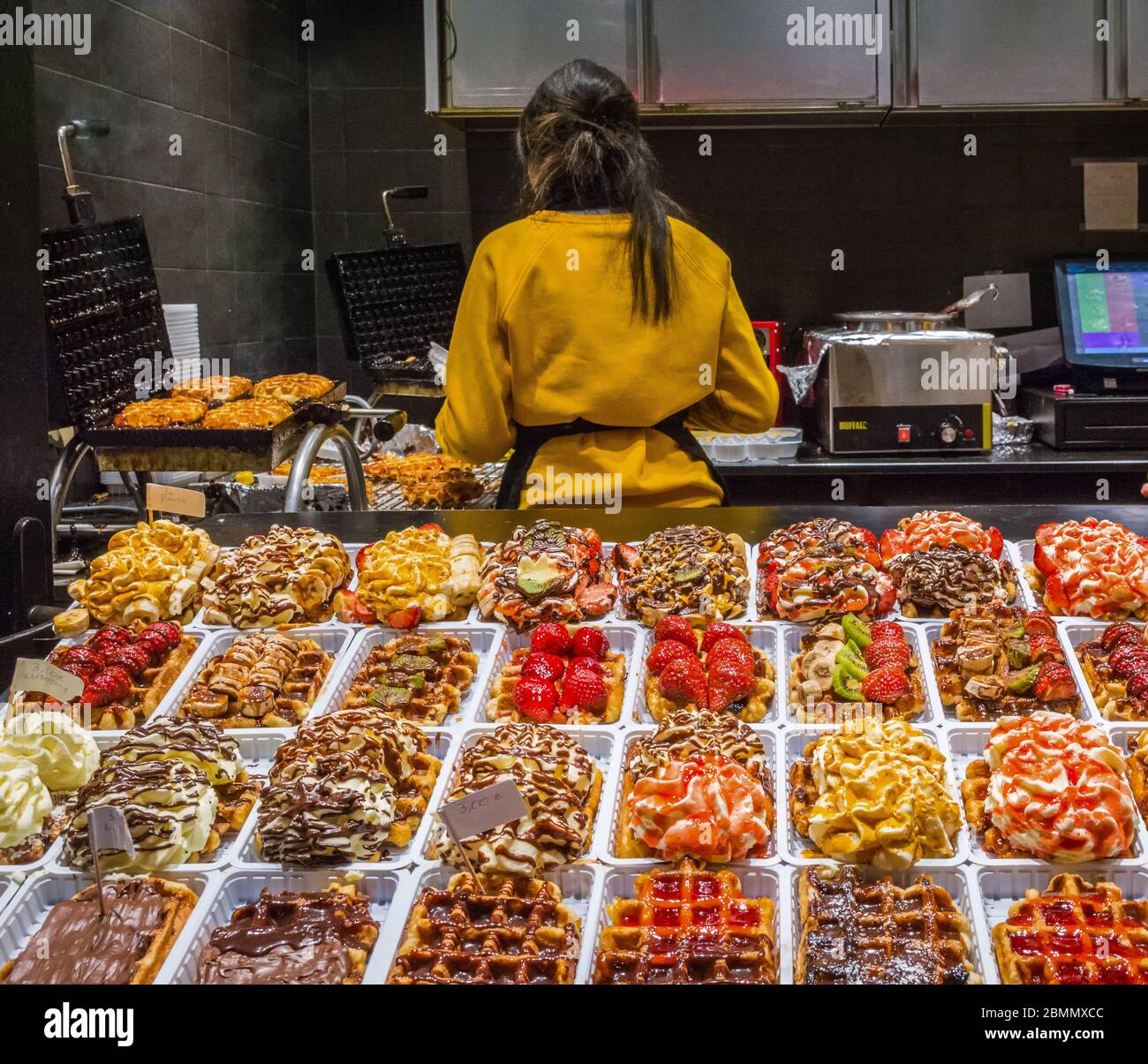woman prepared Belgium waffle on Christmas fair in Brussels, Belgium on December 30, 2019. Stock Photo