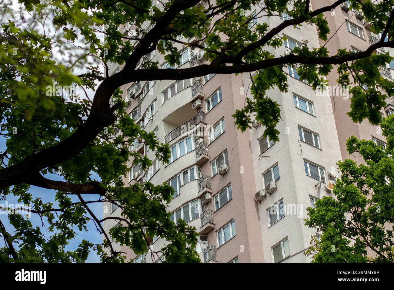 tall apartment building among trees and leaves Stock Photo Alamy