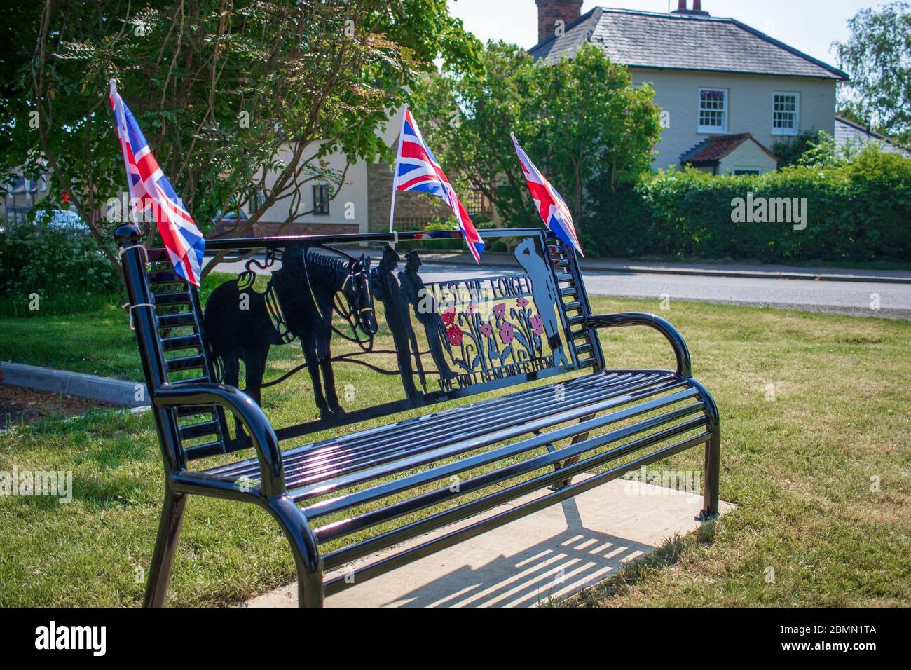 8 May 2020. Sharnbrook village green in Bedfordshire with memorial bench decorated with union jacks for VE Day 75th anniversary Stock Photo