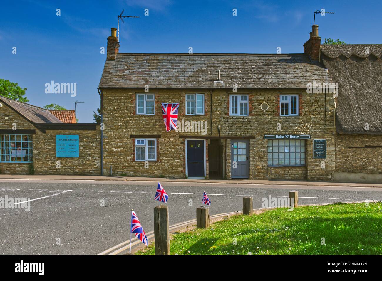 8 May 2020. Cottage and village green in Sharnbrook, Bedfordshire, UK decorated with union jack flags for VE Day 75th anniversary Stock Photo
