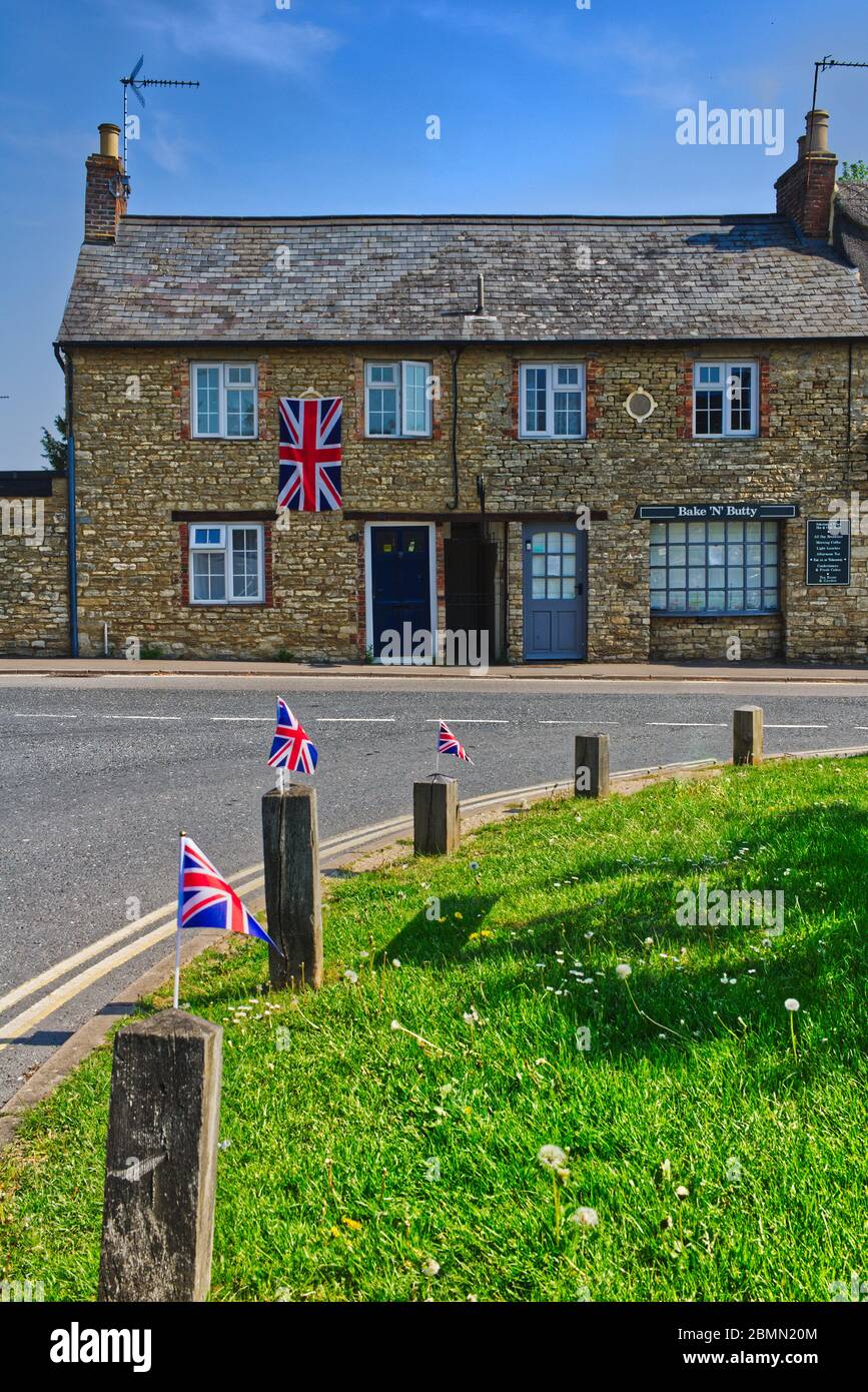 8 May 2020. Cottage and village green in Sharnbrook, Bedfordshire, UK decorated with union jack flags for VE Day 75th anniversary Stock Photo