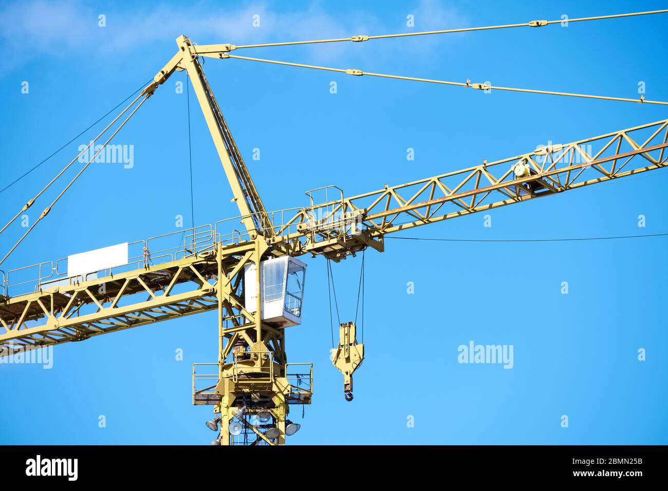 Tower crane high in blue sky close up of lifting hook Stock Photo