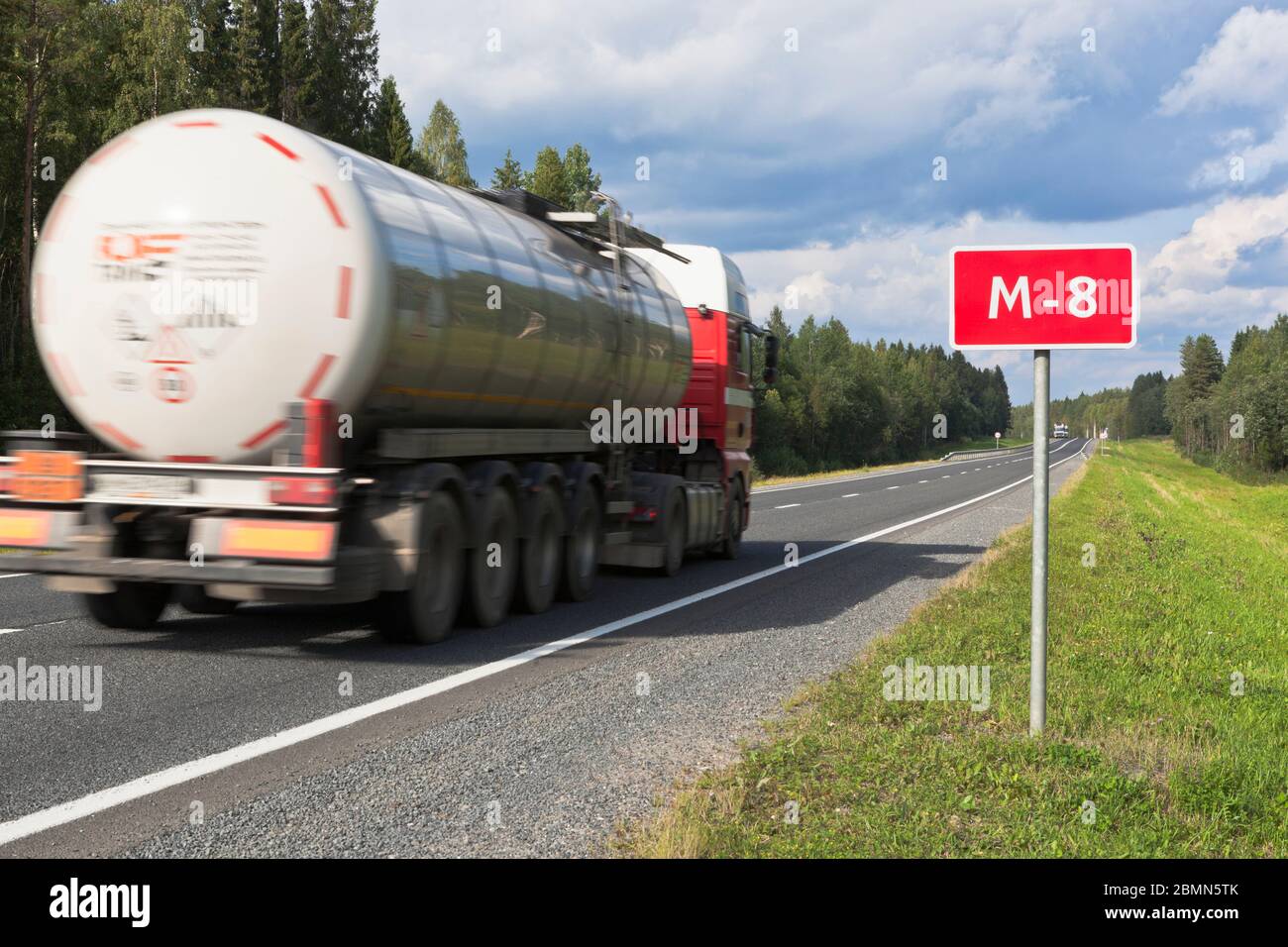 A truck with a tank driving on the M8 road in the Vologda region, Russia Stock Photo