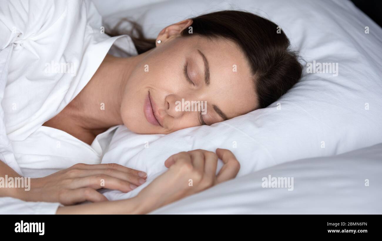 Closeup face of sleeping in bed gorgeous carefree 30s woman Stock Photo