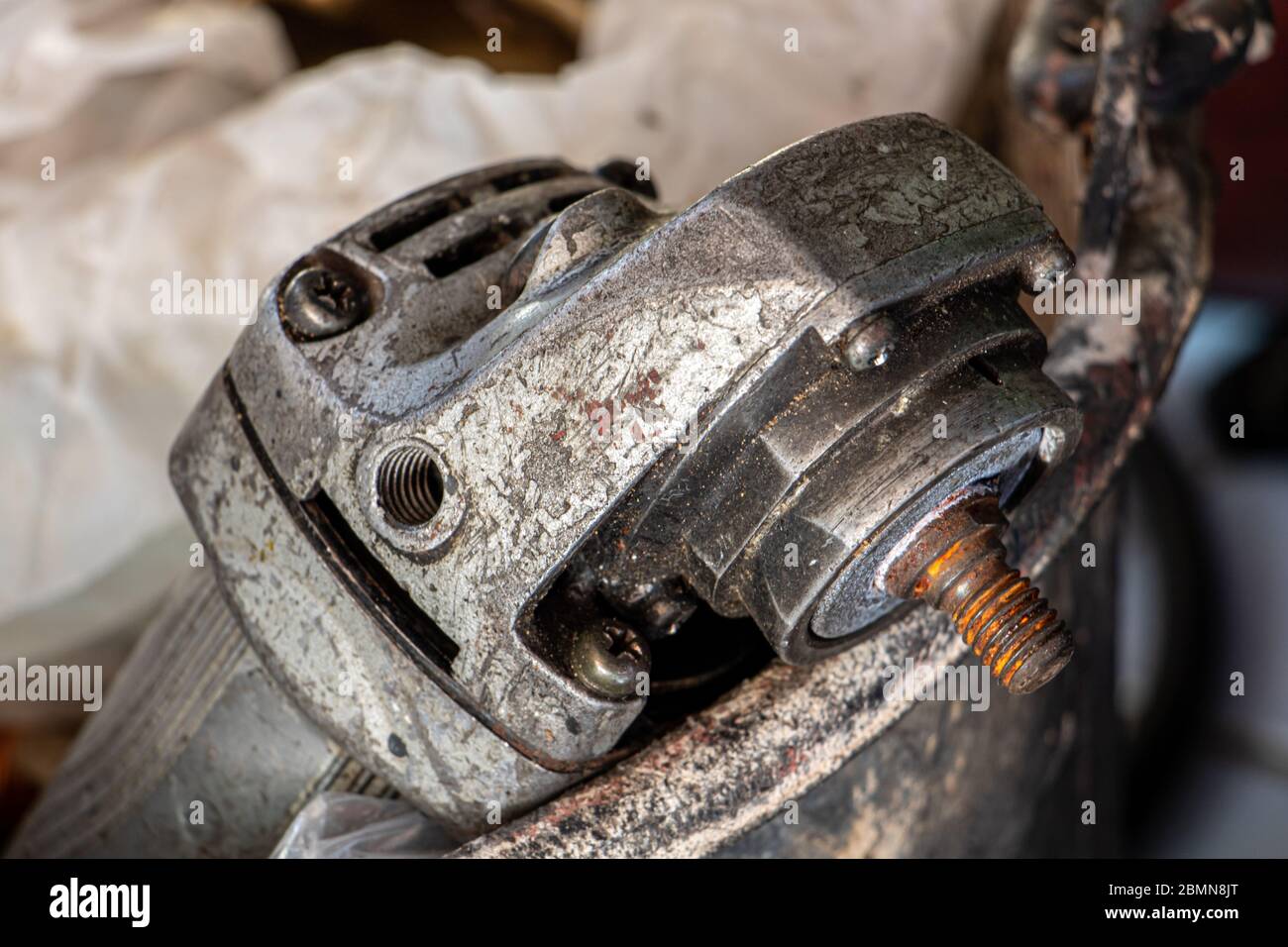 An old angle grinder in bucket. A damaged electrical hand tool ready for repair. Stock Photo