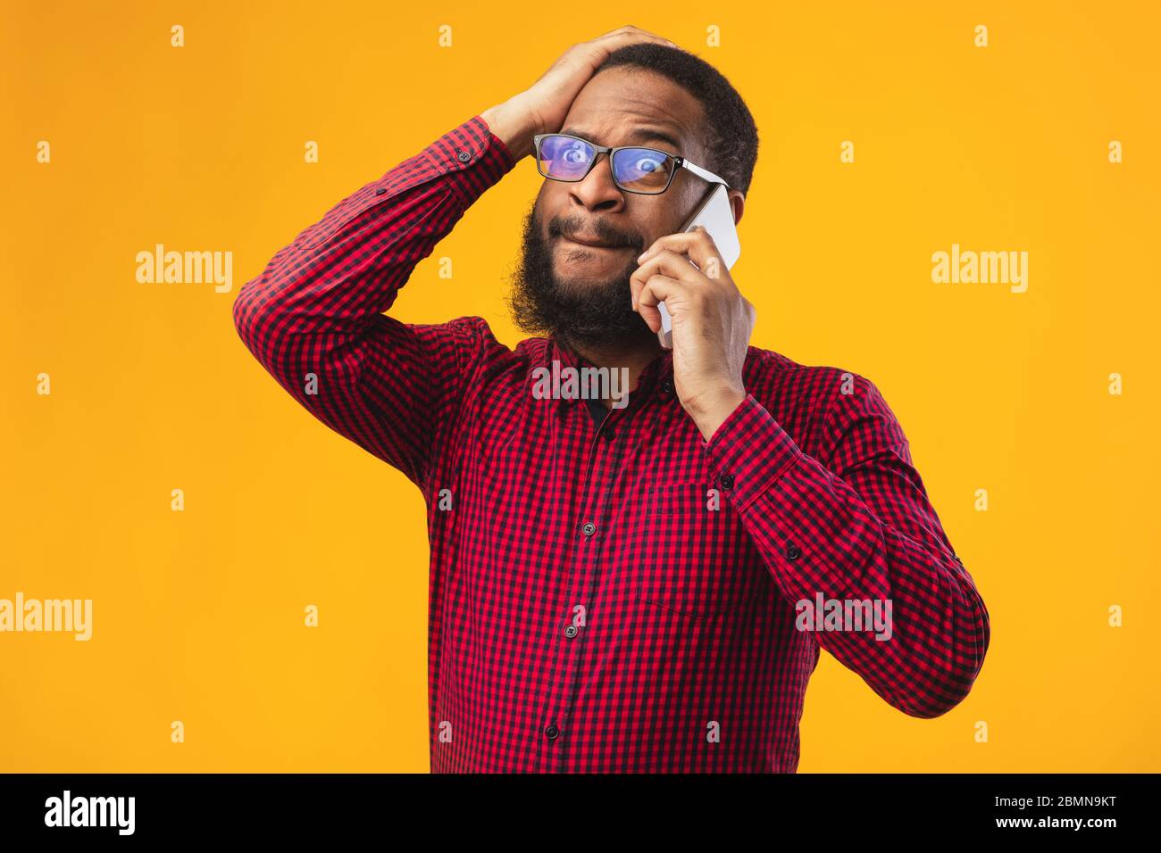 Surprised black guy talking on the phone and gesturing Stock Photo