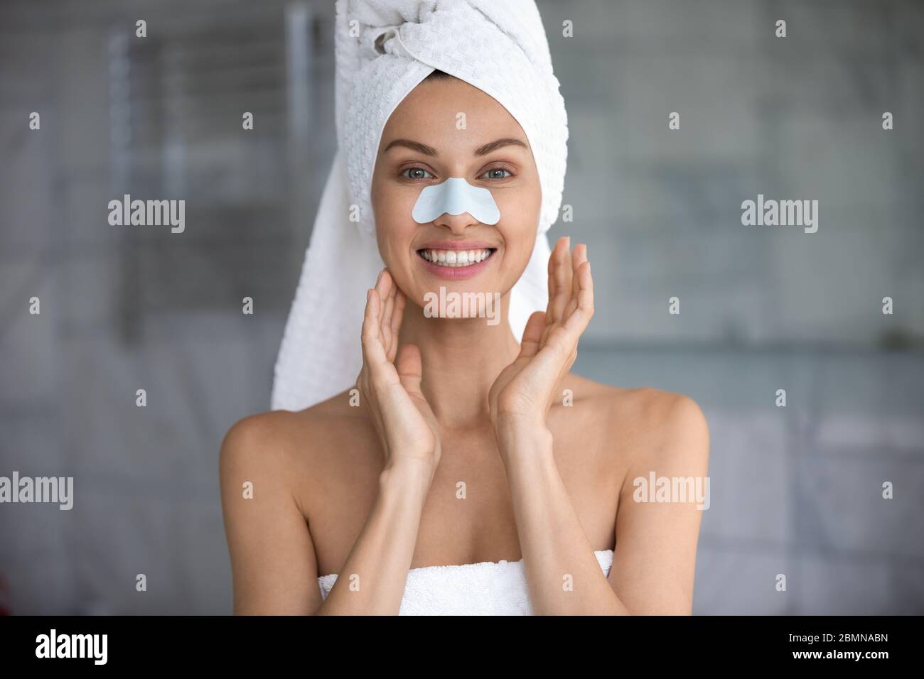 Woman apply cleansing pore nose strips smiles looks at camera Stock Photo