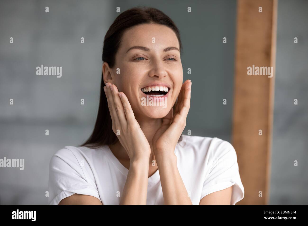 Beautiful woman touch face enjoys perfect skin after moisturizing cream Stock Photo