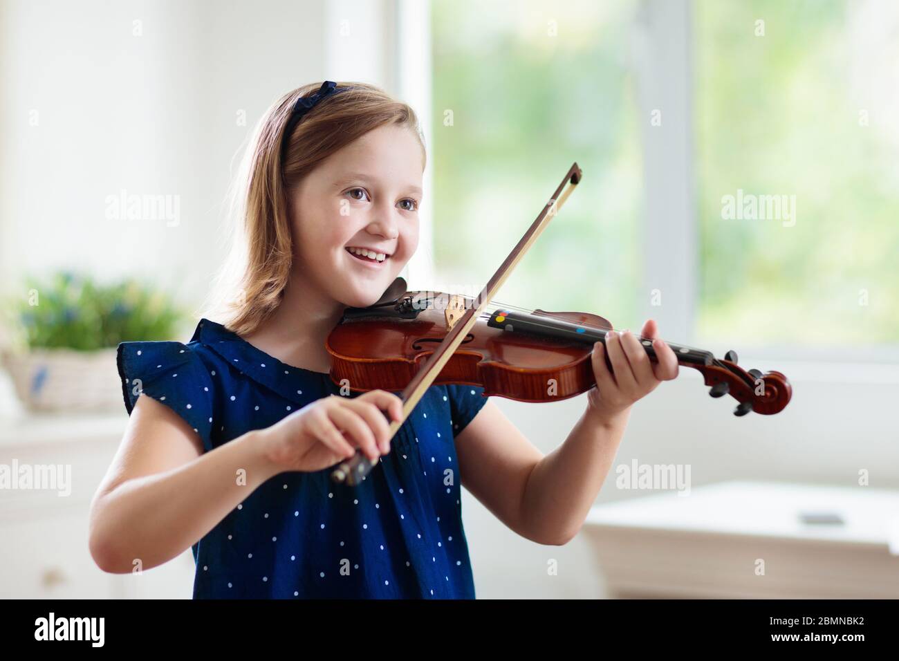 Child playing violin. Remote learning from home. Arts for kid. Little girl  with musical instrument. Video chat conference lesson. Online music tuition  Stock Photo - Alamy