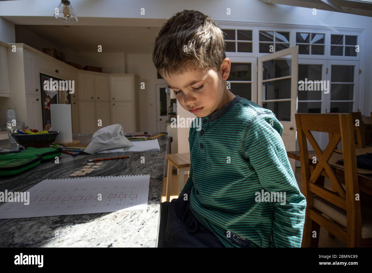 Frustrated six year old boy, home schooling during the coronavirus lockdown closed all schools across the United Kingdom Stock Photo
