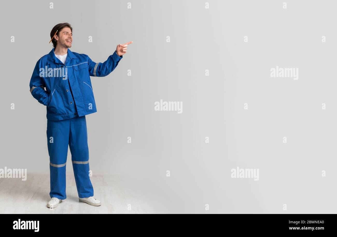 Civil Engineer In Work Uniform Pointing Aside At Copy Space Stock Photo