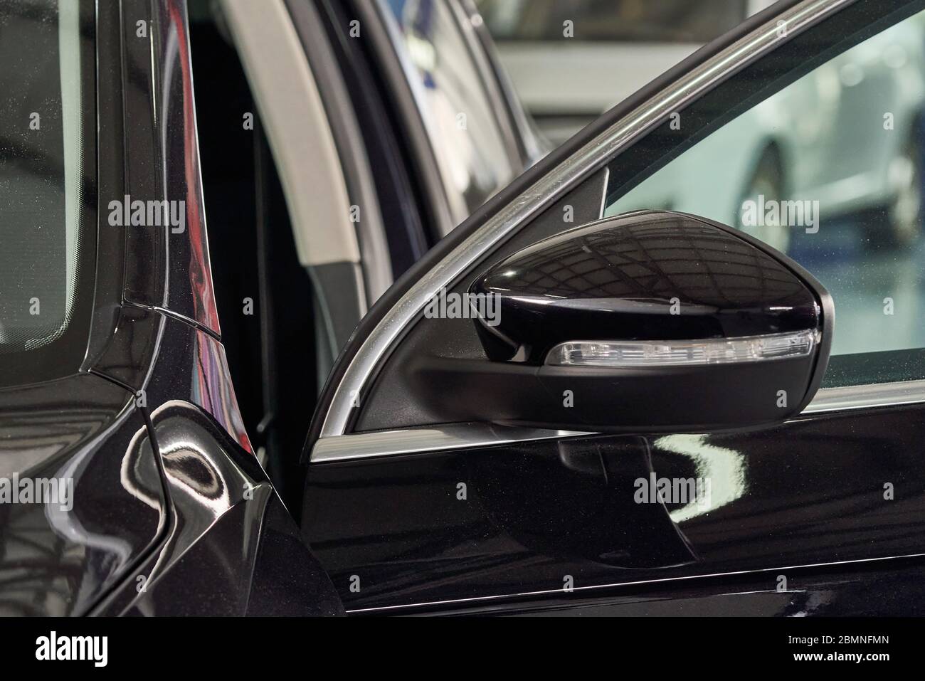 Closeup shot of black modern car's side mirror in auto repair shop