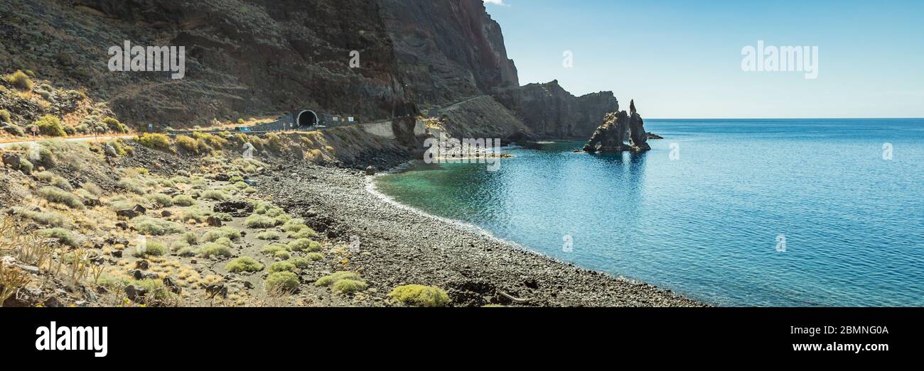 Wide angle panorama. Roque de Bonanza is one of the symbols of El Hierro island and its natives. Huge Rock sticking out of the water on the las Almorr Stock Photo
