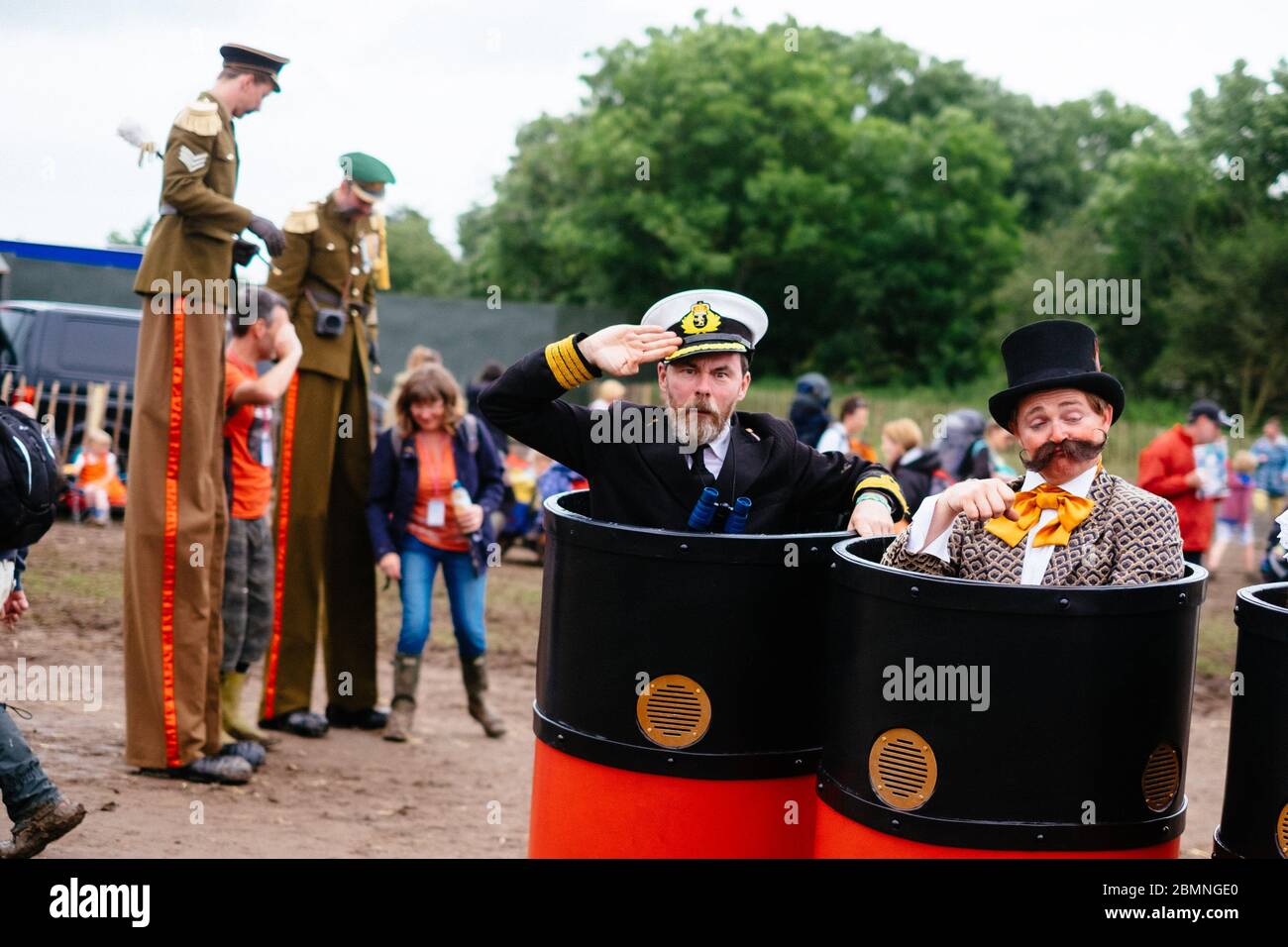 Missing Link Productions' Funnels, walkabout act in the Theatre & Circus area, with The Sergeant Majors stiltwalkers in the background   Glastonbury F Stock Photo