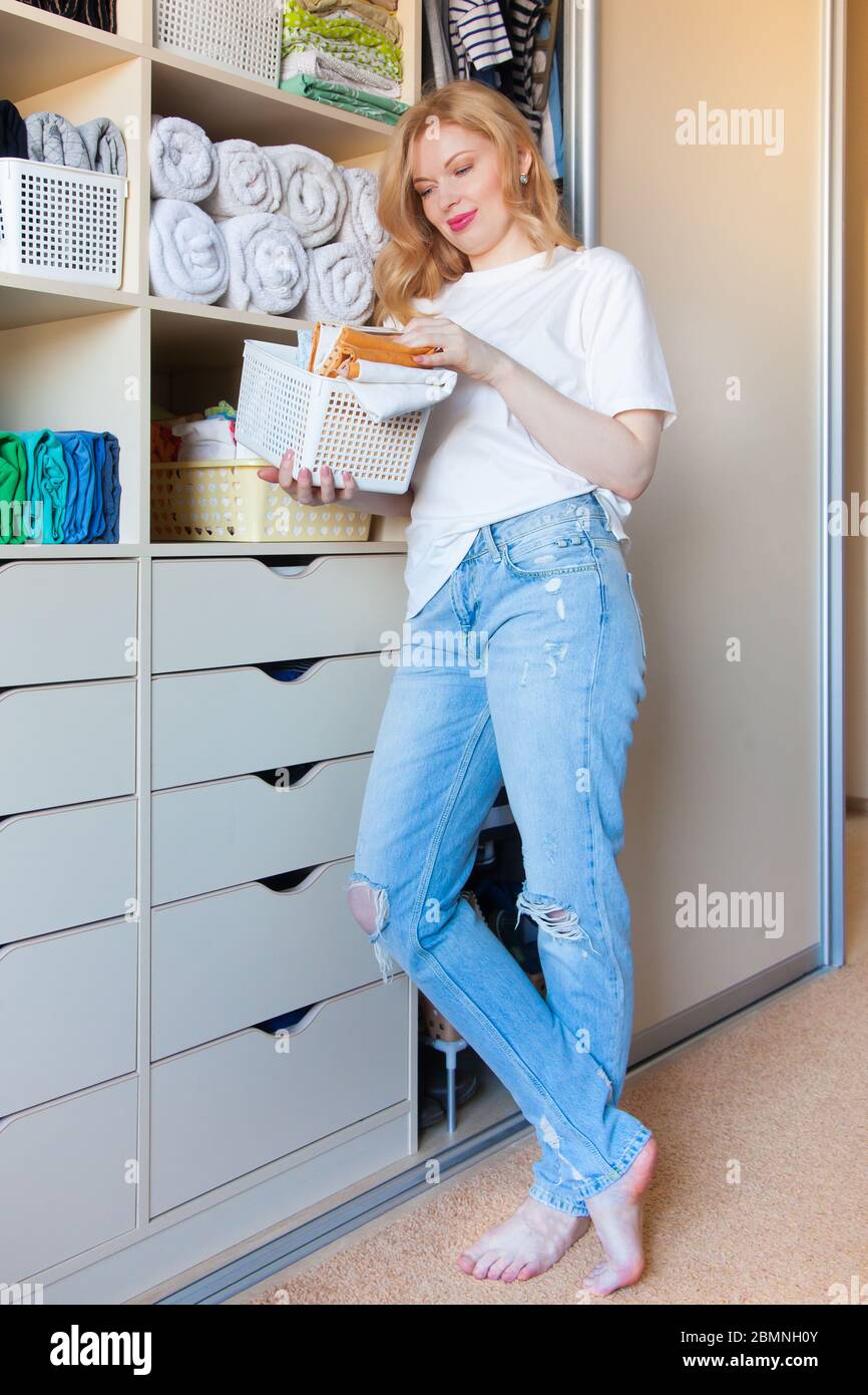 The girl puts things in order in the wardrobe. Vertical Japanese