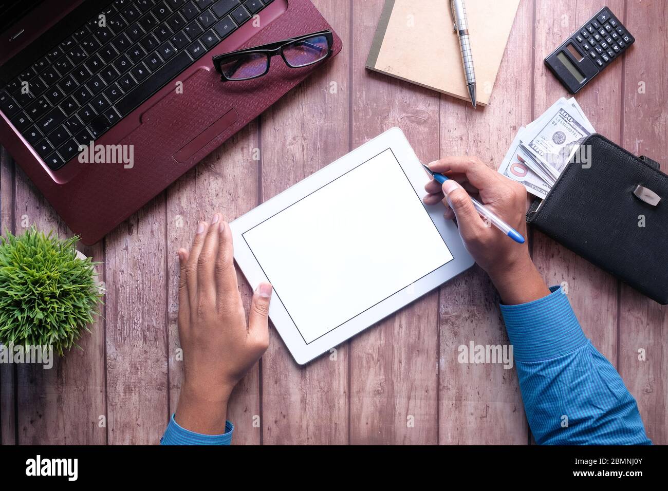 young man working on digital tablet with laptop and notepad on table Stock Photo