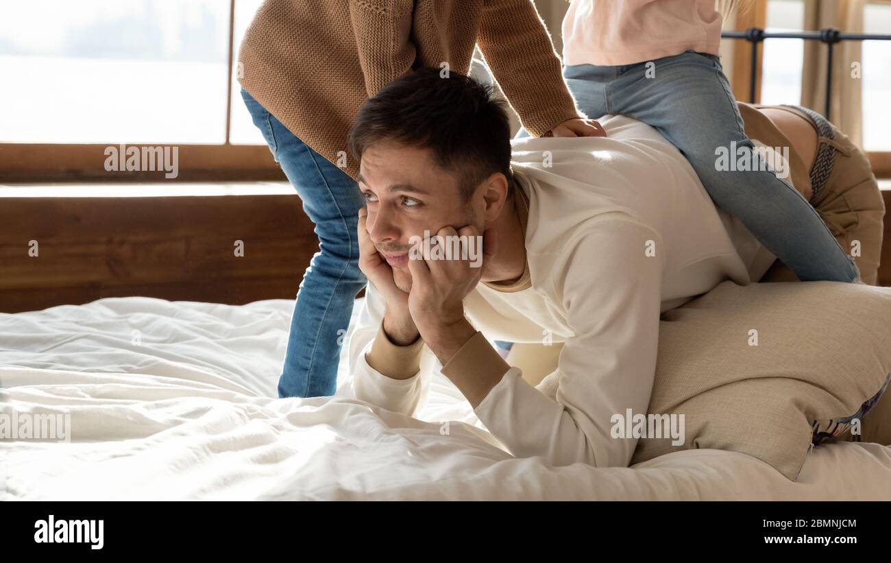 Stressed tired father having problem with noisy naughty children Stock Photo