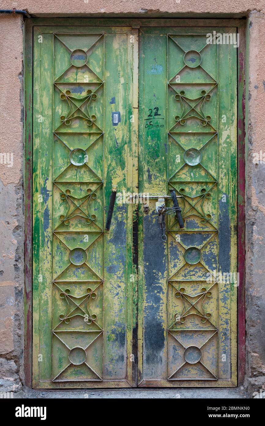 Traditional green and blue Omani wooden door with metal embellishments in Al Hamra Stock Photo