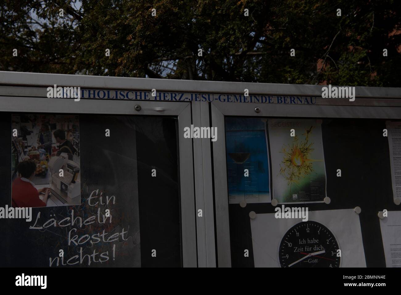 Bernau, Germany. 15th Apr, 2020. Information showcases of the Catholic Sacred Heart Jesus parish with a poster 'A smile costs nothing'. Credit: Paul Zinken/dpa-Zentralbild/ZB/dpa/Alamy Live News Stock Photo