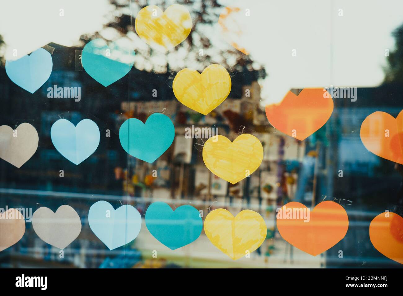 Close up hand made paper hearts in rainbow colors and form on the window showcase. The symbol for supporting for many meanings Stock Photo