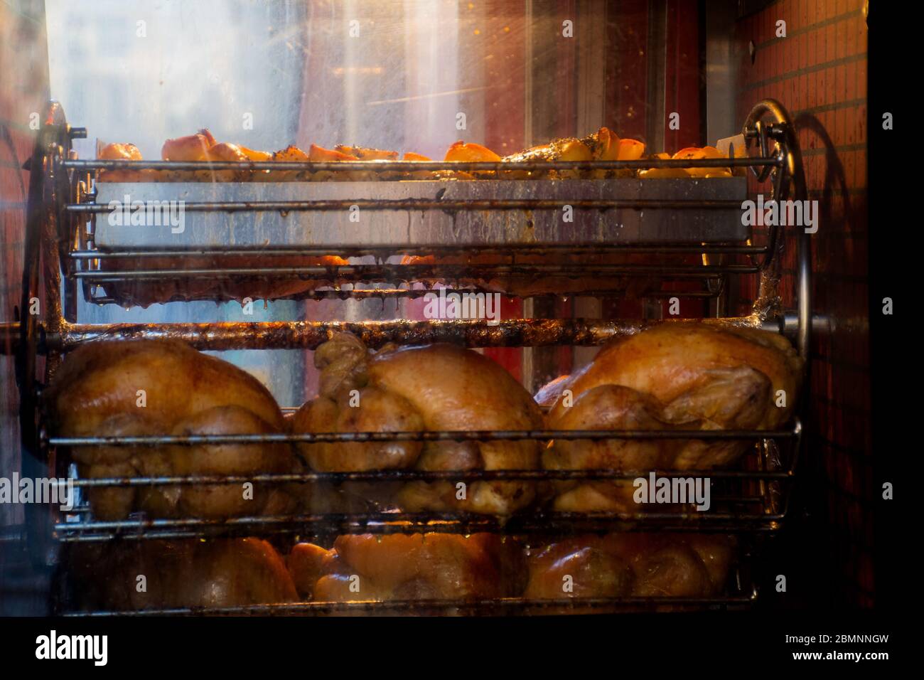 Greasy unhealthy chicken roasting in the oven Stock Photo Alamy
