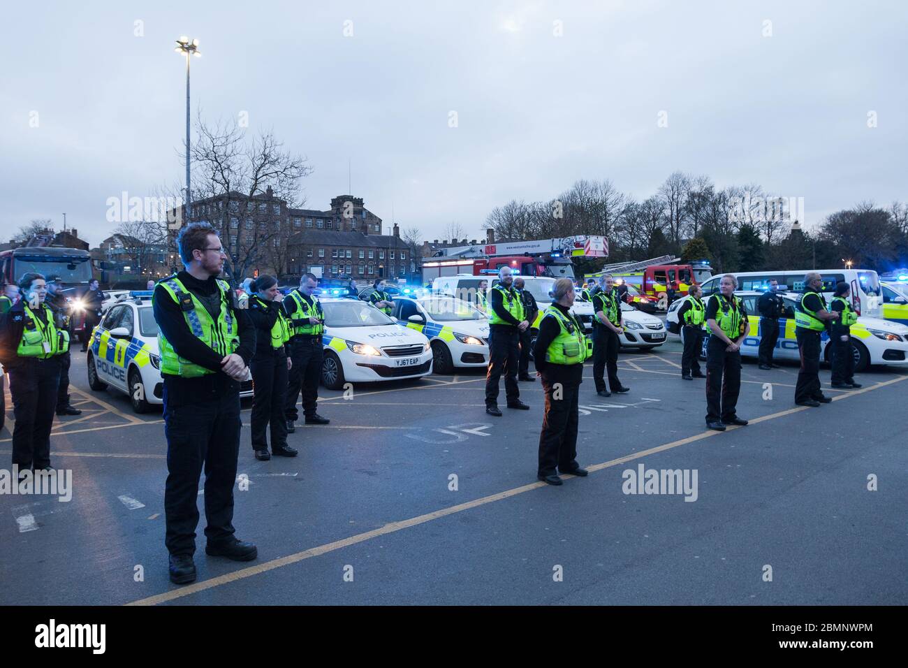 HUDDERSFIELD, WEST YORKSHIRE, UK - APRIL 9: West Yorkshire Police and West Yorkshire Fire and Rescue line up to applaud NHS workers in front of Hudder Stock Photo