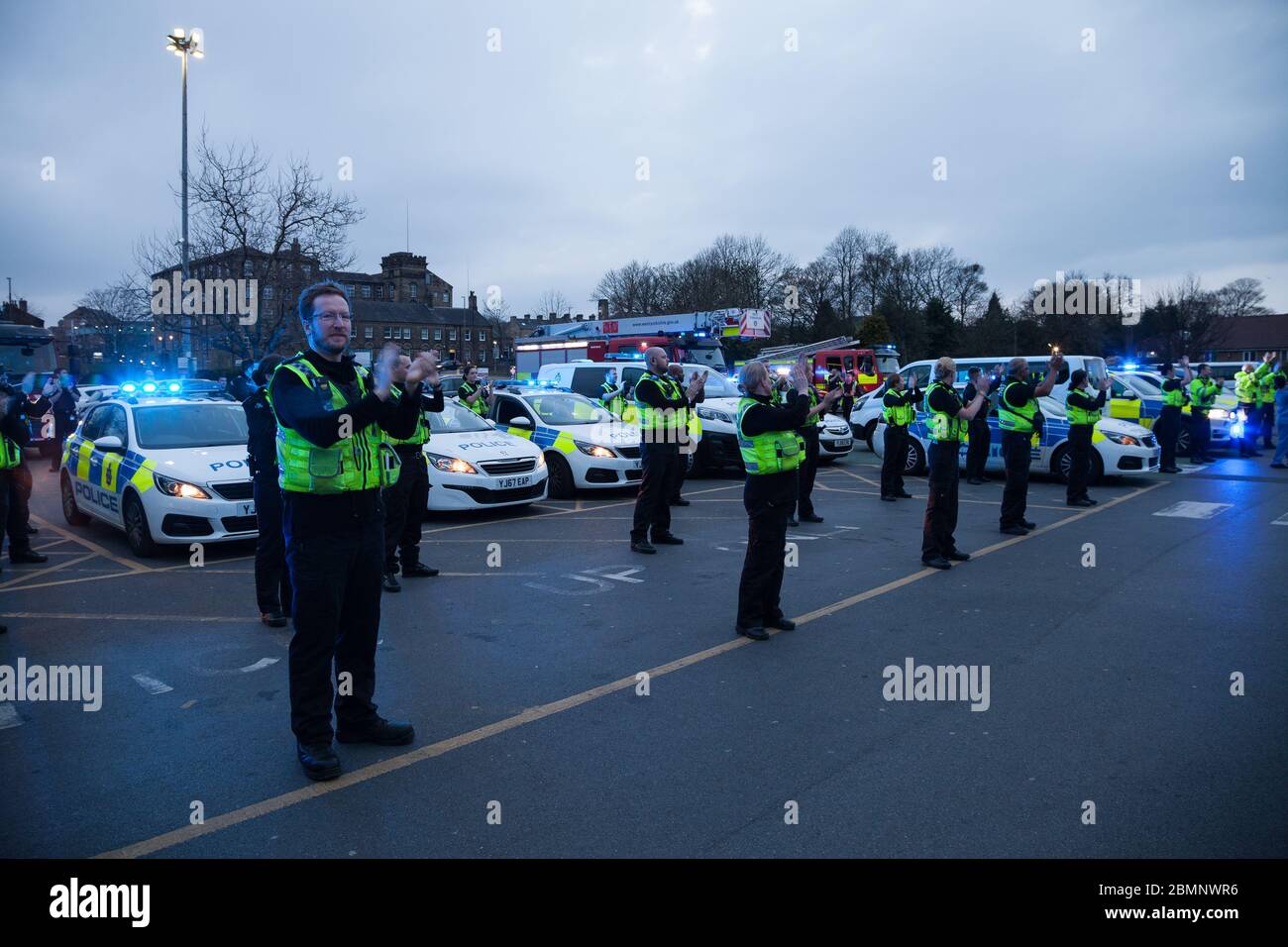 West Yorkshire Police and West Yorkshire Fire and Rescue clap for NHS workers in front of Huddersfield Royal Infirmary during the Coronavirus outbreak. Stock Photo