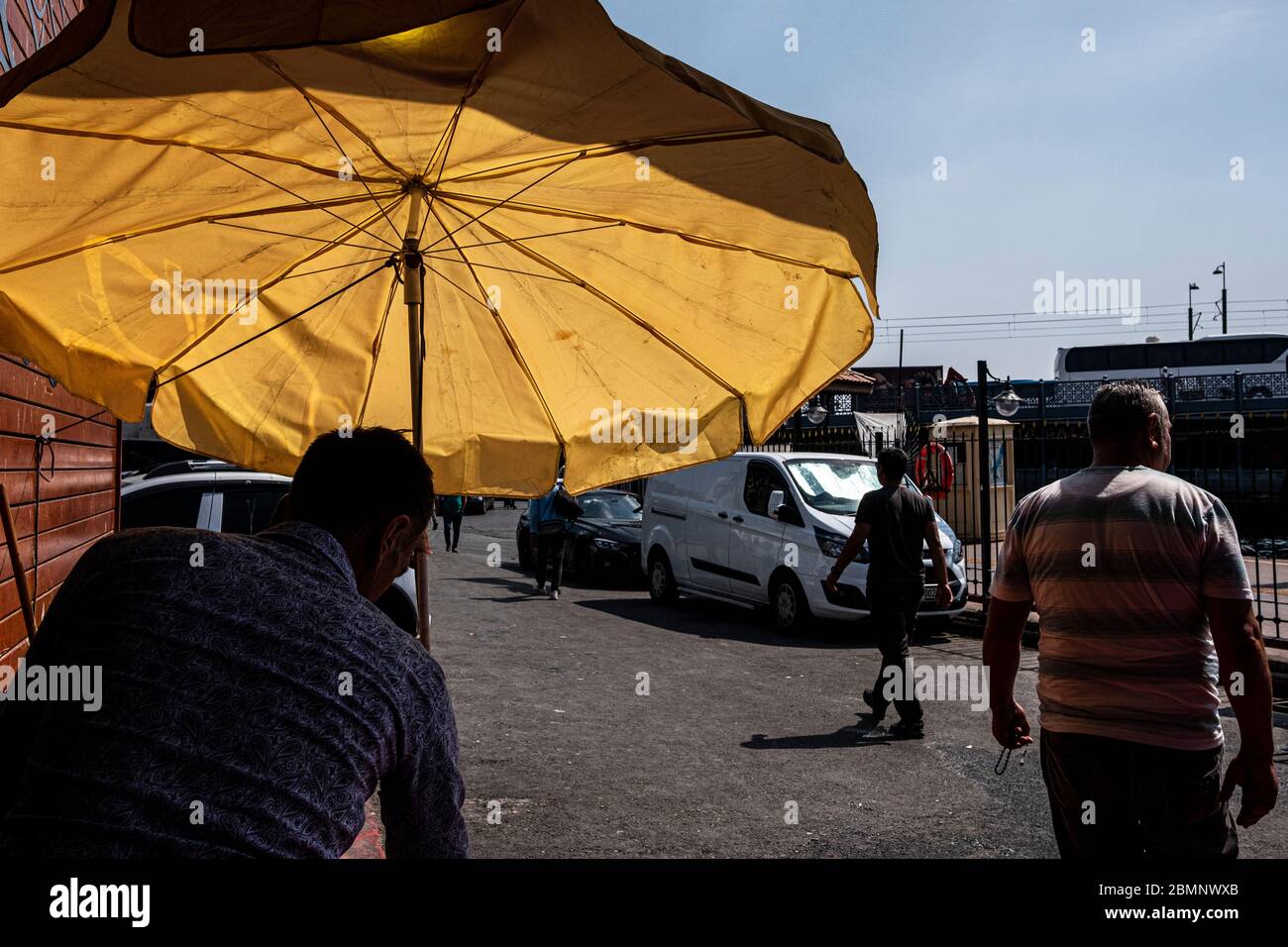 Istanbul, Turkey - 03 September 2019 : Yellow sun umbrella near Karakoy fish market Stock Photo