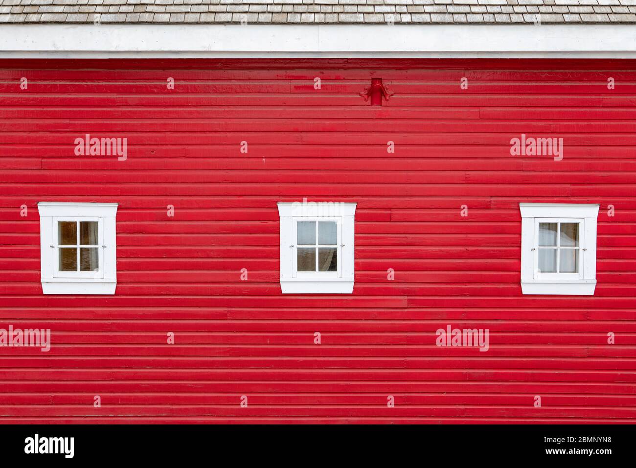 The classic red wood panel barn with white windows Stock Photo