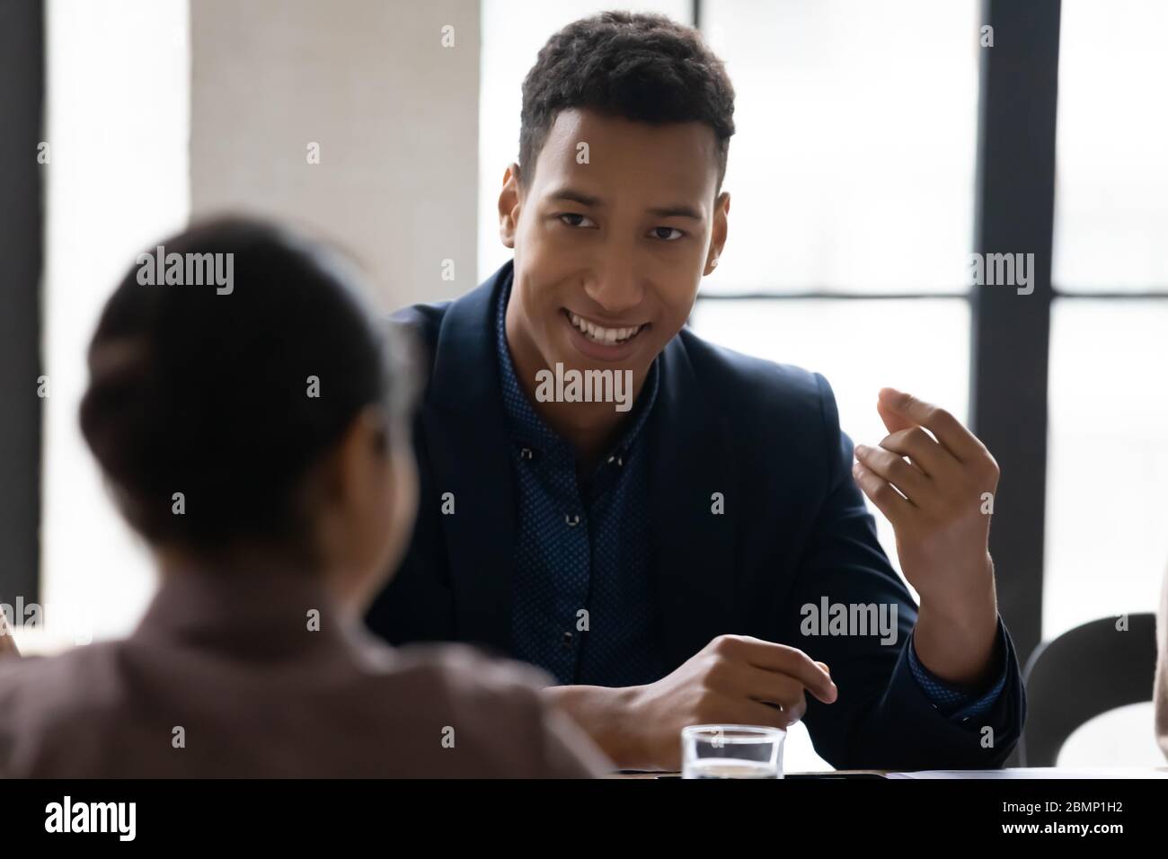 Close up african american businessman talking with female colleague. Stock Photo