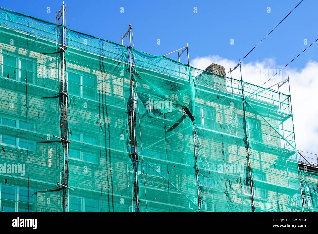 green safety net on scaffolding at the facade of an apartment house
