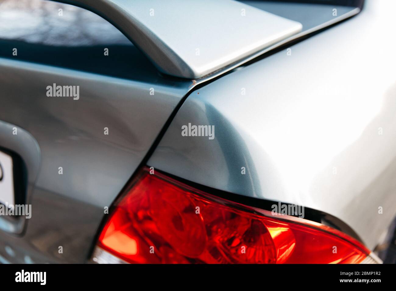 The taillight of a car is broken. Blue passenger car. Dent and scratch on the rear fender.Road accident. Stock Photo