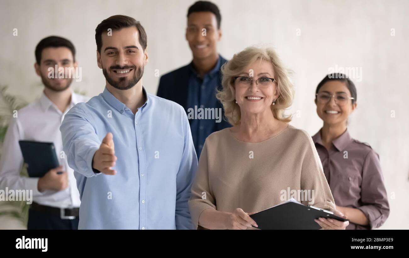 Two happy businessman shaking hand posture and mature businesswoman. Stock Photo
