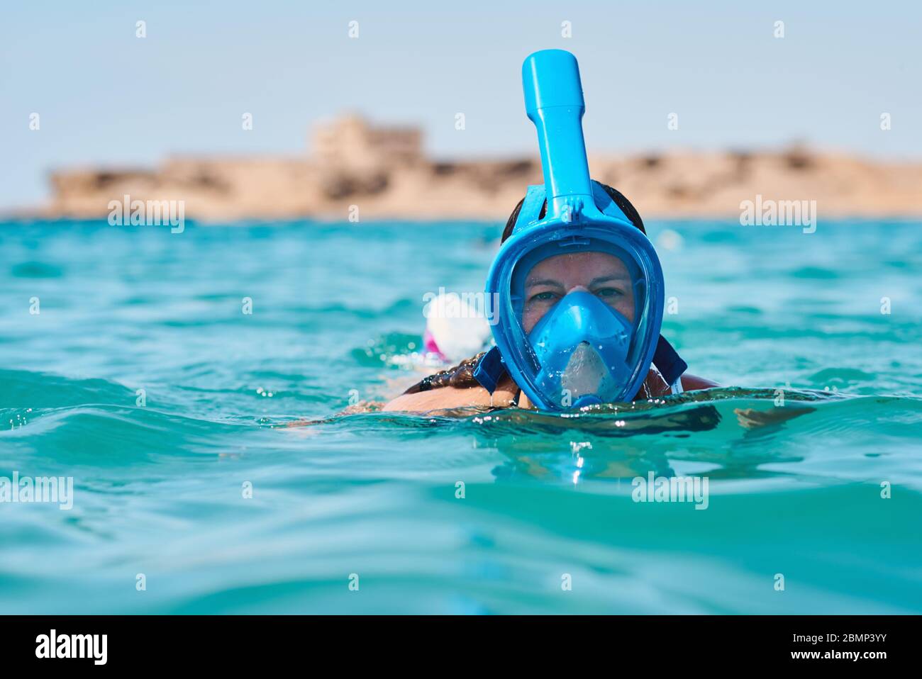 Woman with snorkel full face mask diving in blue sea. Summer vacation Stock Photo