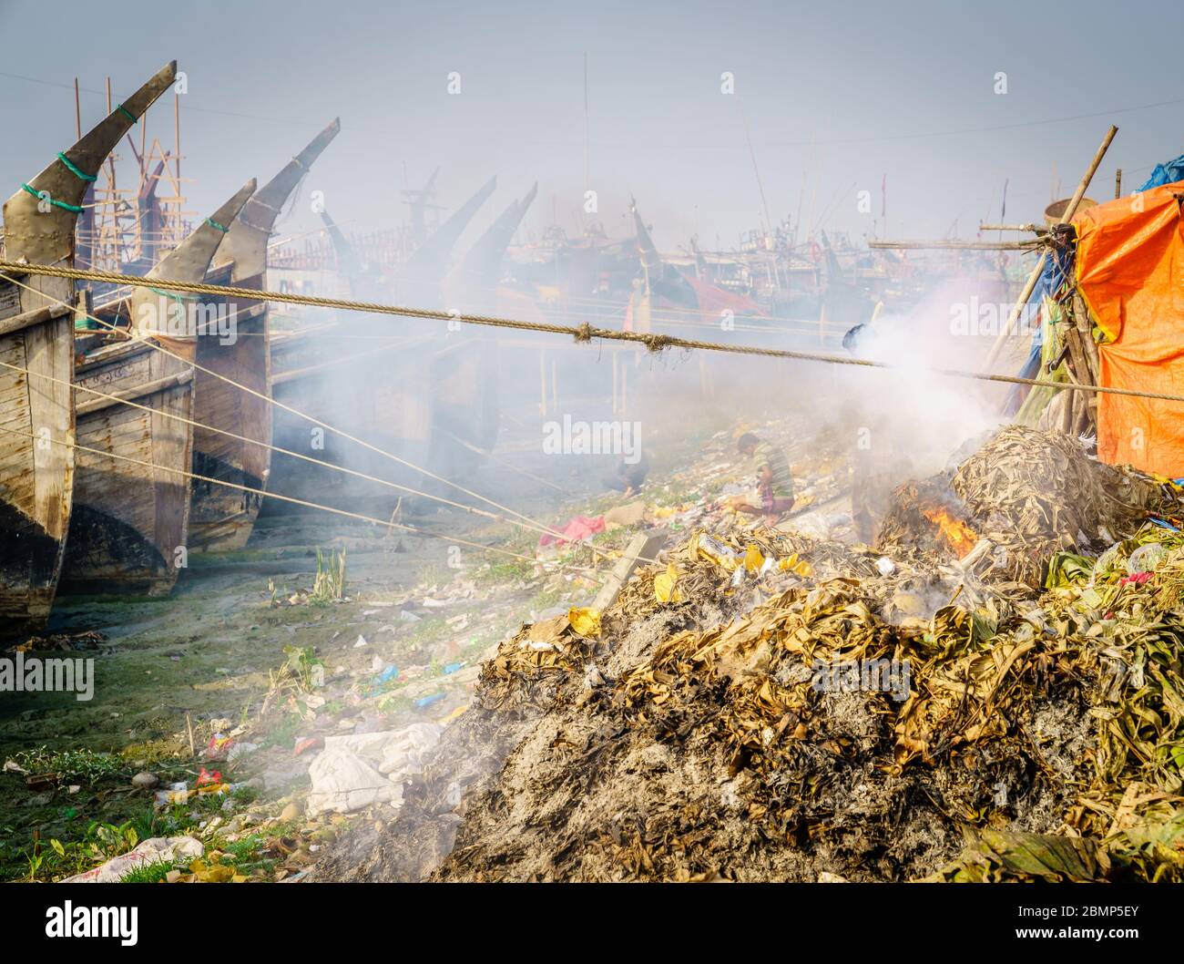 Seaweed smoldering on the bank of the Karnaphuli River in Chittagong, Bangladesh Stock Photo