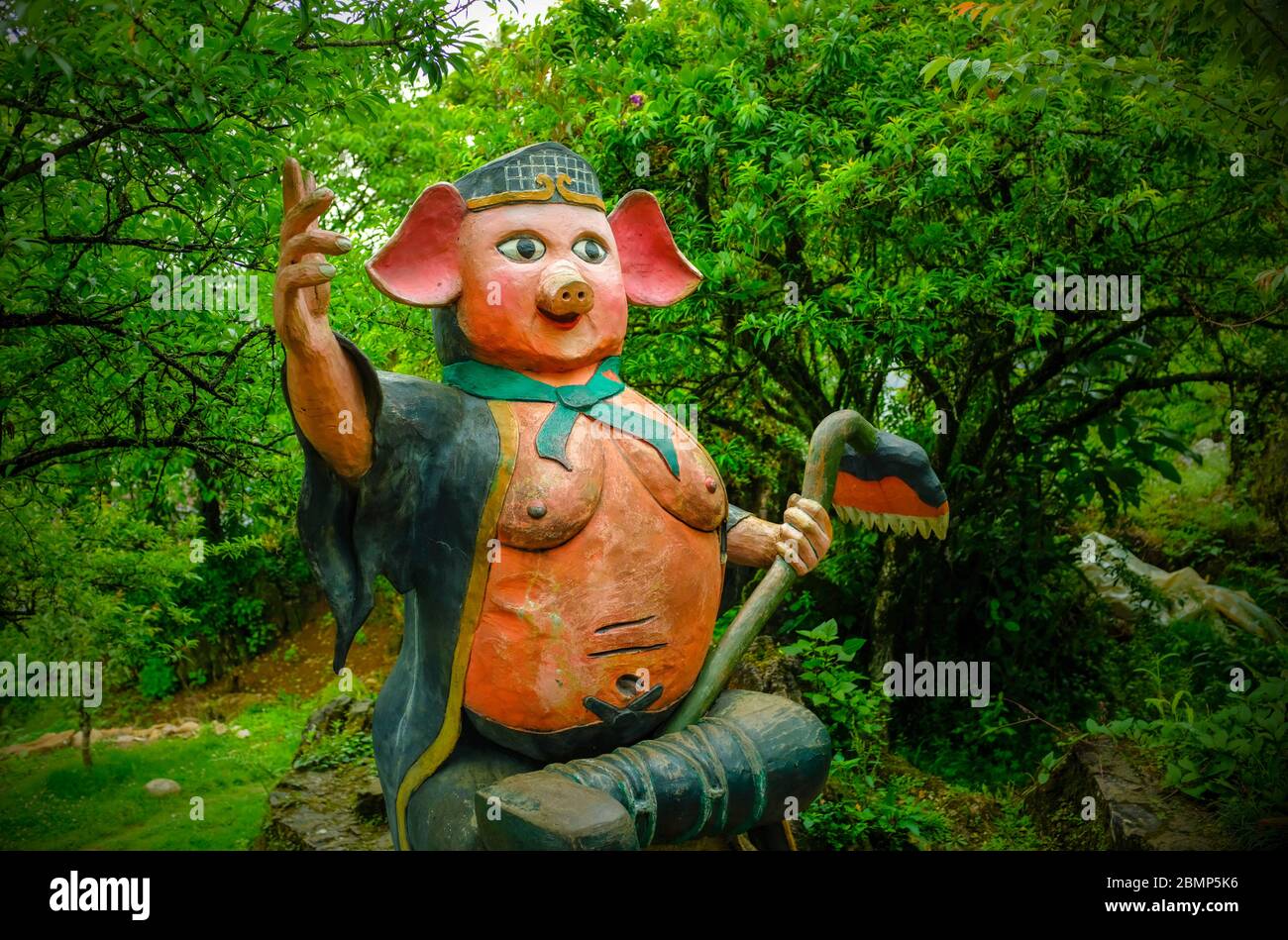 Sa pa, Vietnam - April 26, 2018: Naive art painted wood sculpture of a pig, taken on an overcast day with trees in the background Stock Photo