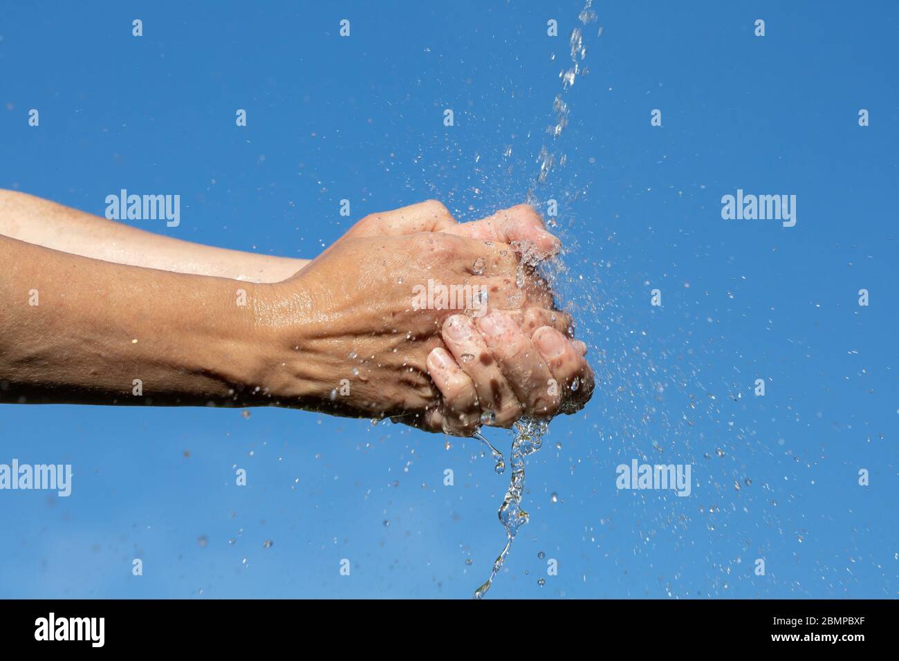 Washing hands under running water in nature Stock Photo