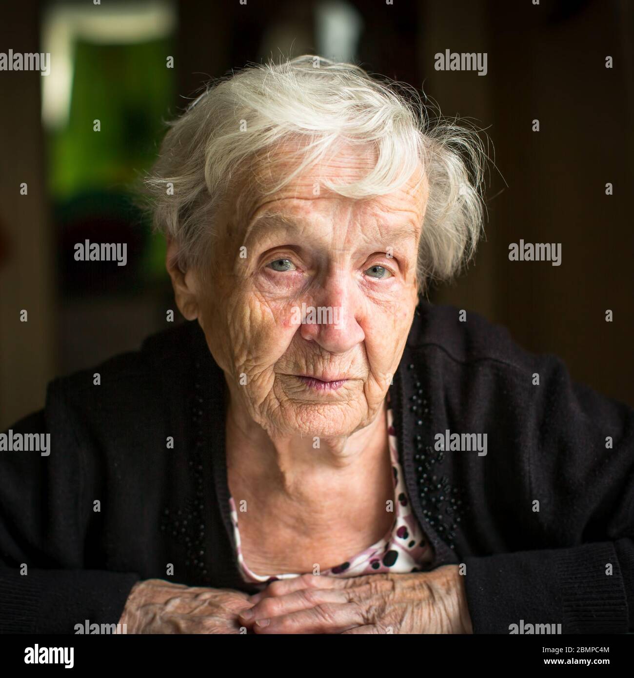 Close-up portrait of old woman, sitting in the her home Stock Photo - Alamy