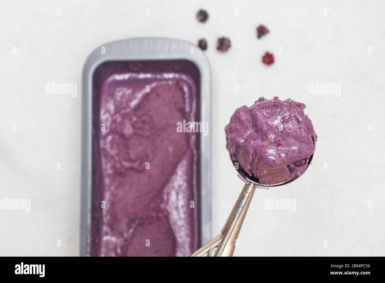 Scoop of vegan blackberry ice cream on neutral background Stock Photo