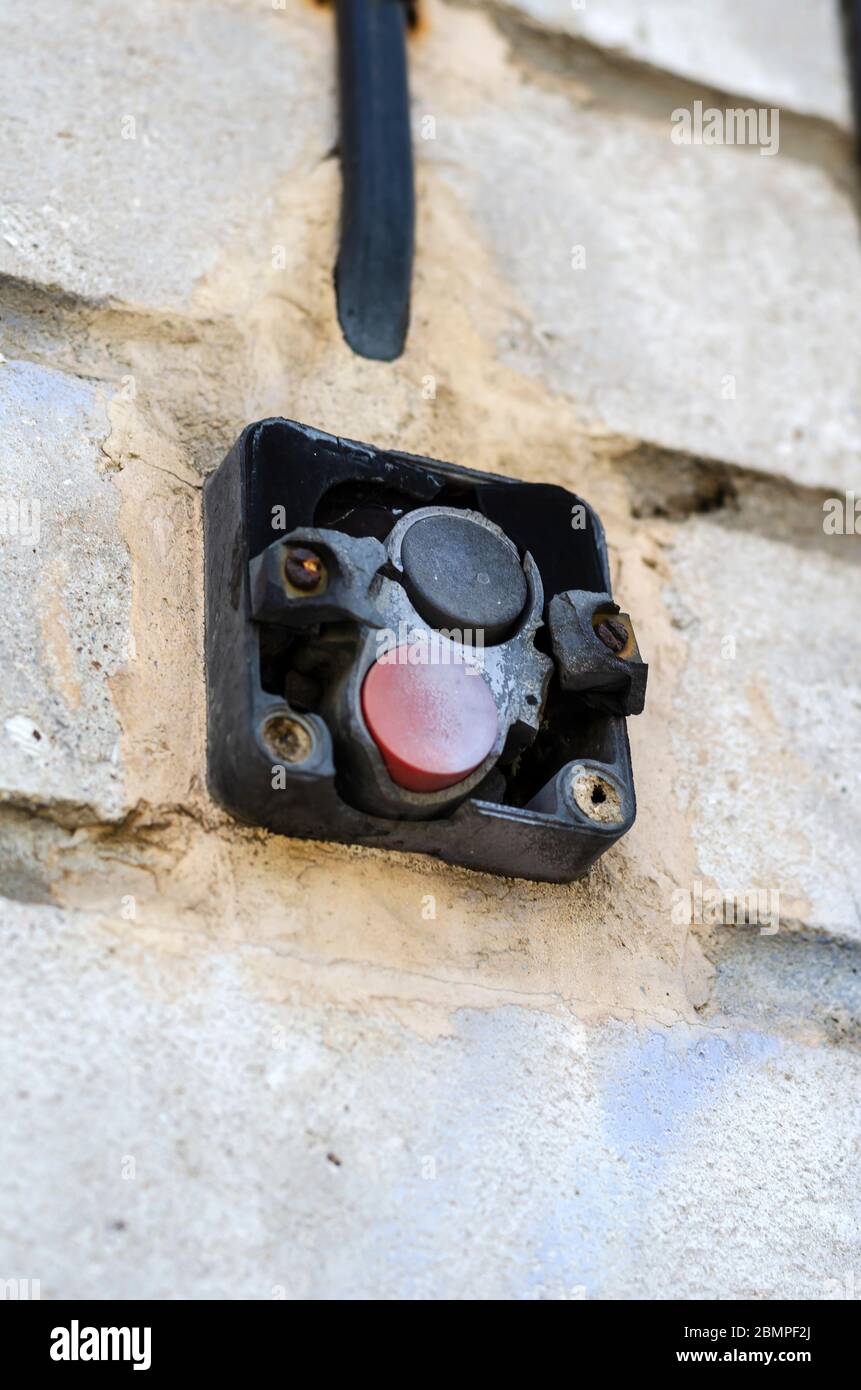Carbonized industrial starting switch in a brick wall of a workshop ...