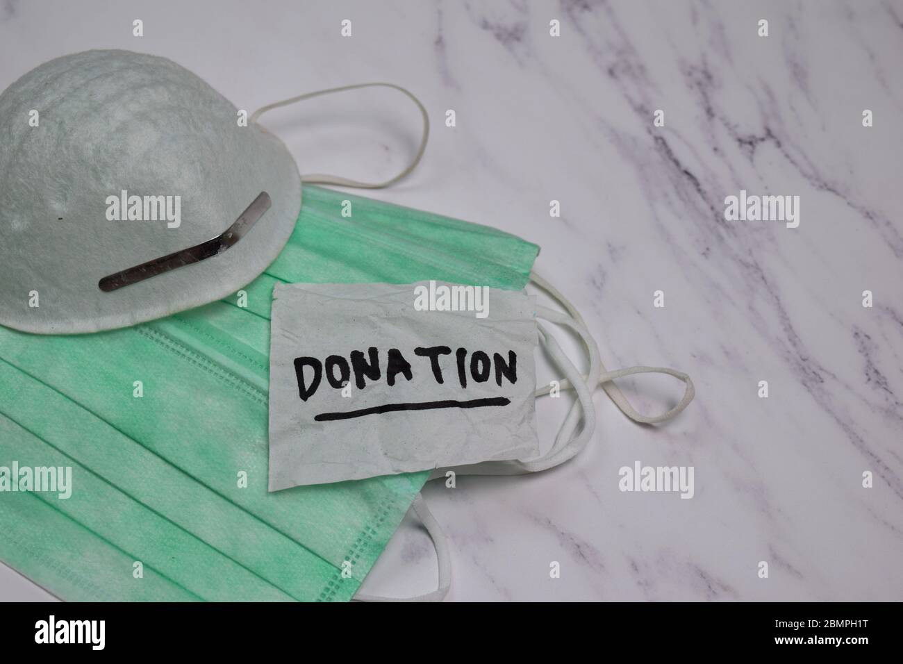 Donation write on sticky notes with health mask isolated on office desk