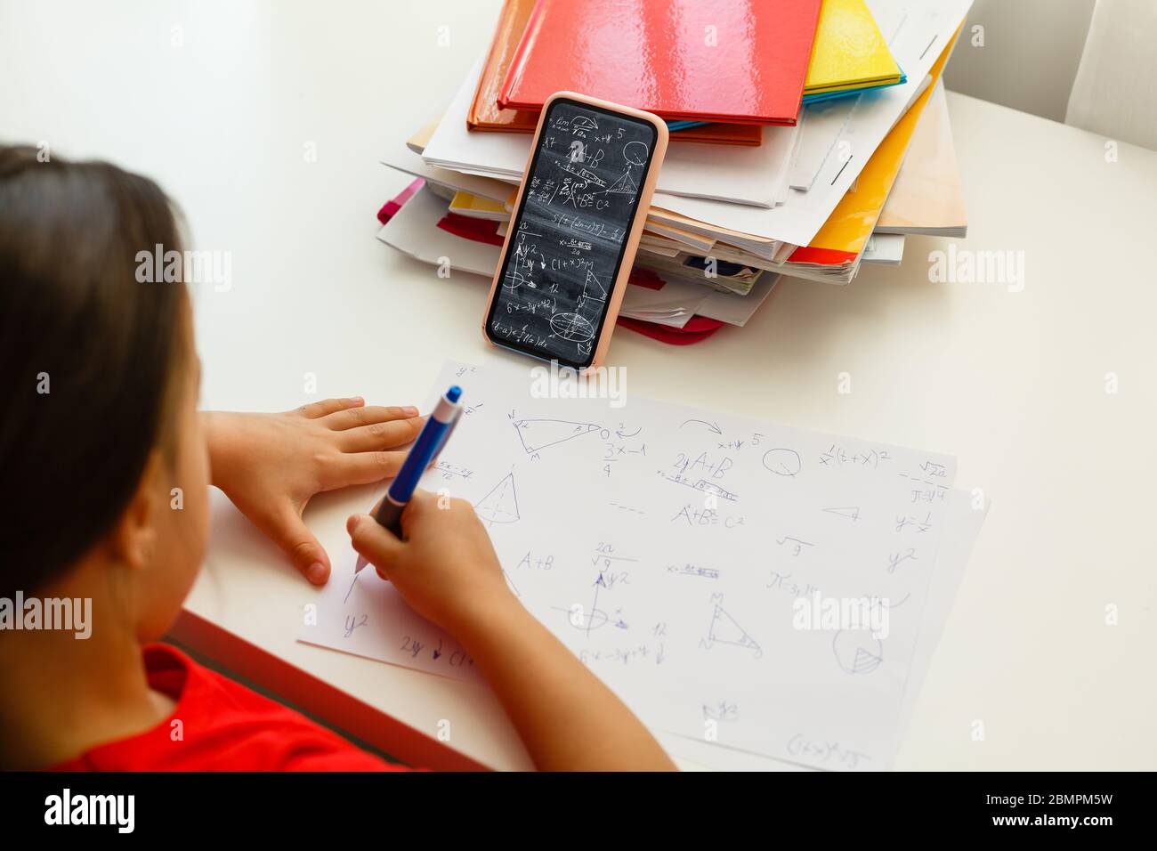 Distance learning online education, little girl writes formulas Stock Photo