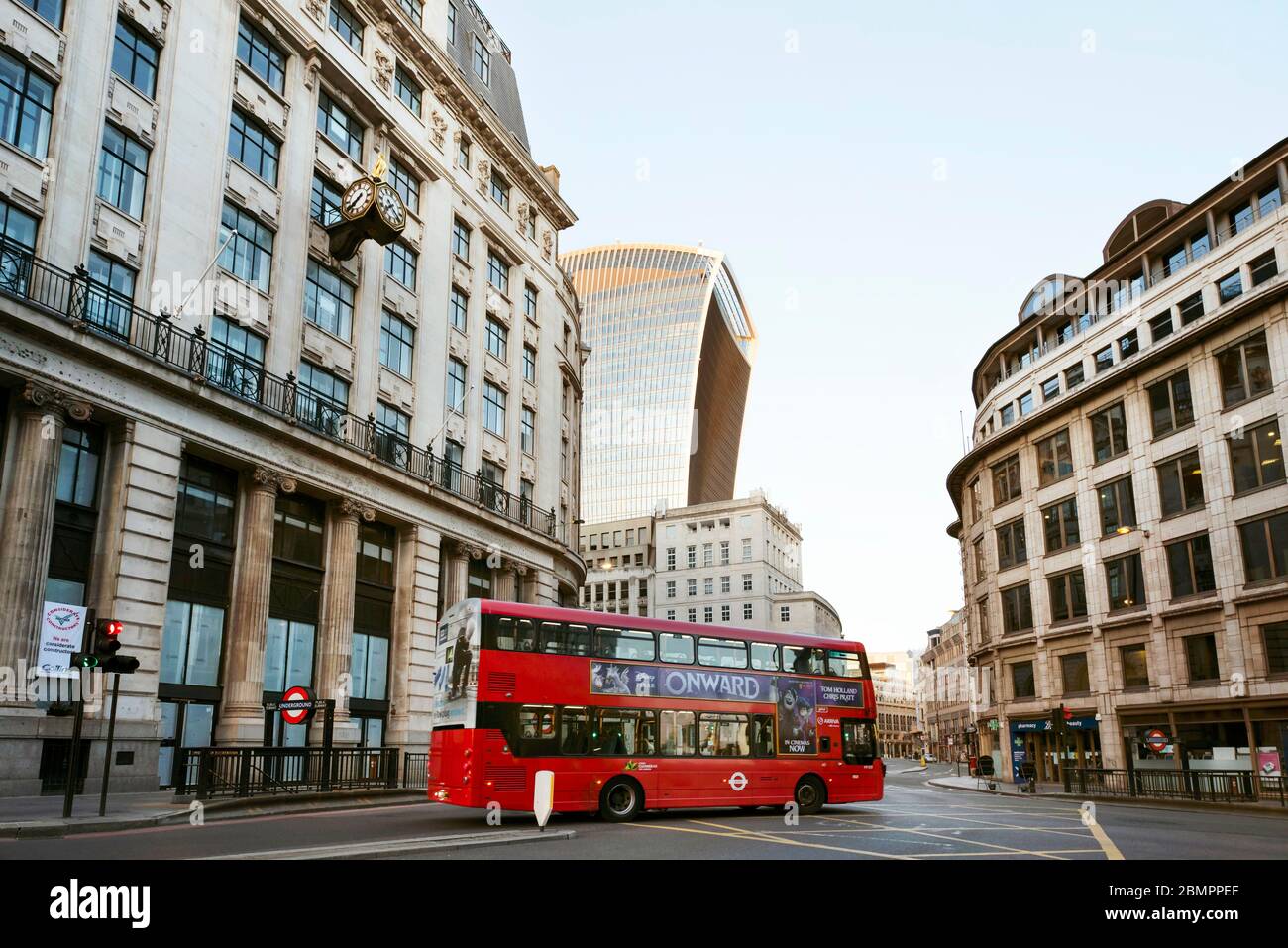 Wide angle street shot with empty bus passing Monument station on day 7 of the lockdown. King William Street, the City of London, Mar 2020 Stock Photo