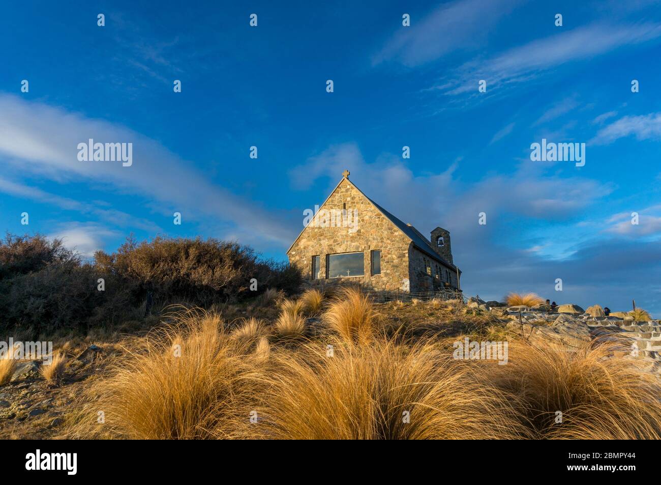 Historic building of church of Good Shepherd with dry tussock grass on the foreground. New Zealand historic landmarks tourist destination background Stock Photo