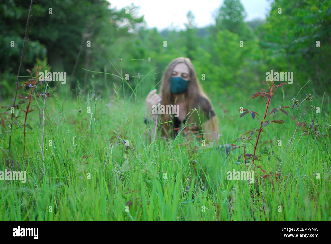A woman wearing a mask in a field. Stock Photo