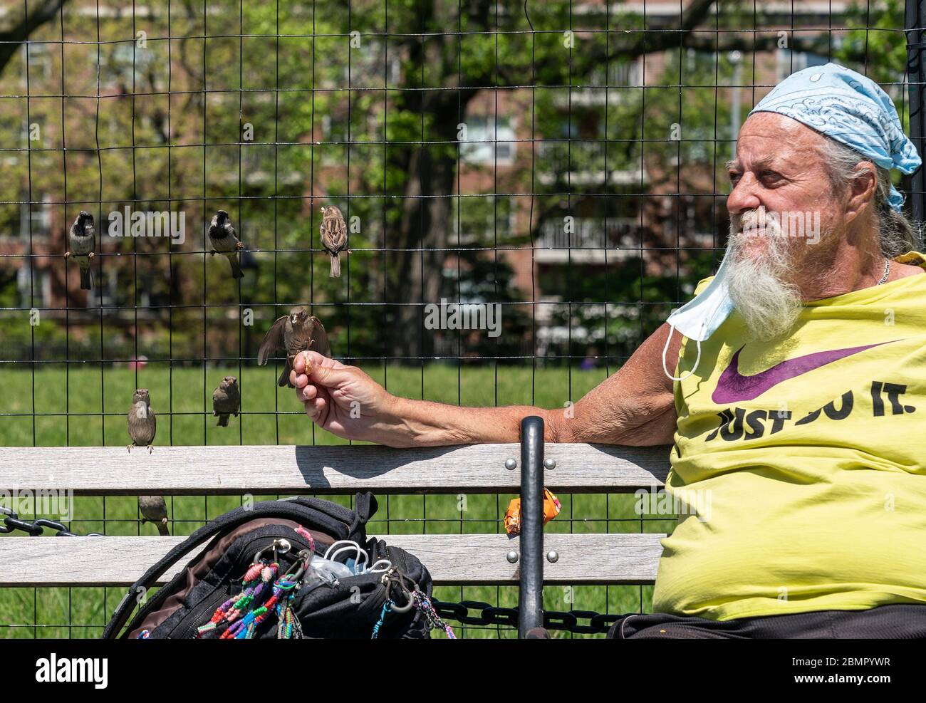 New York, United States. 10th May, 2020. A man named Ronnie feed sparrows and enjoys sunny day amid COVID-19 pandemic in Washington Square Park (Photo by Lev Radin/Pacific Press) Credit: Pacific Press Agency/Alamy Live News Stock Photo