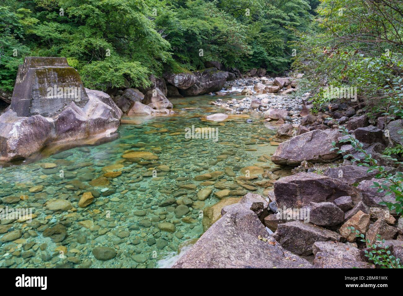 Beautiful clear blue green water shore rocks boulders hi-res stock ...