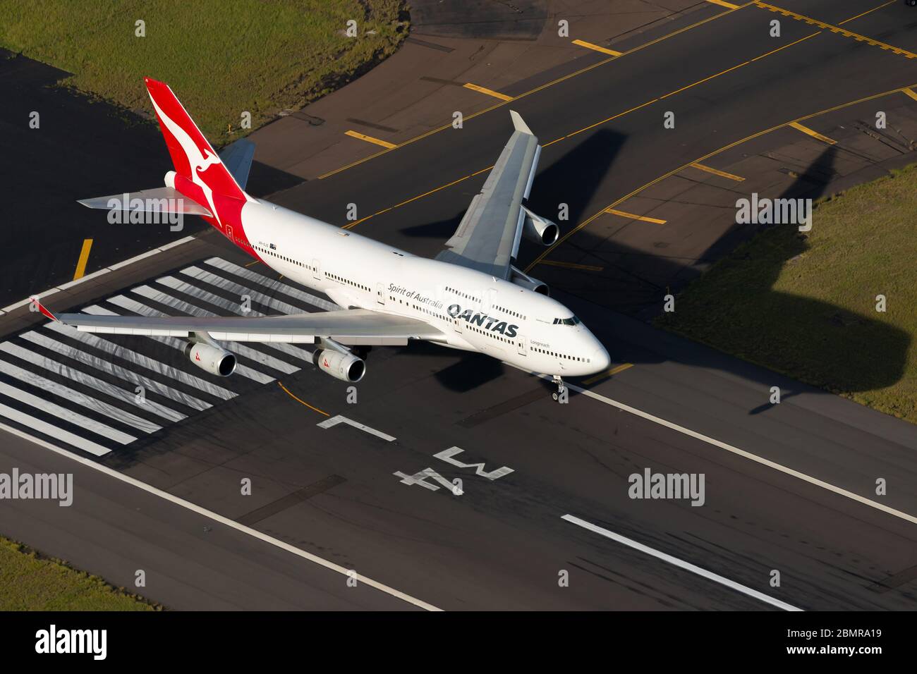 Qantas Airways Boeing 747 over Sydney International Airport runway threshold before landing. Aerial view of Australian airline Jumbo 747-400 landing. Stock Photo