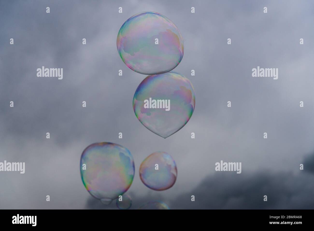 Big soap bubbles against the background of cloudy sky. Stock Photo